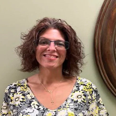 Beverly, Voice Provisioner at iGo Technology, smiling in a floral dress in the iGo office