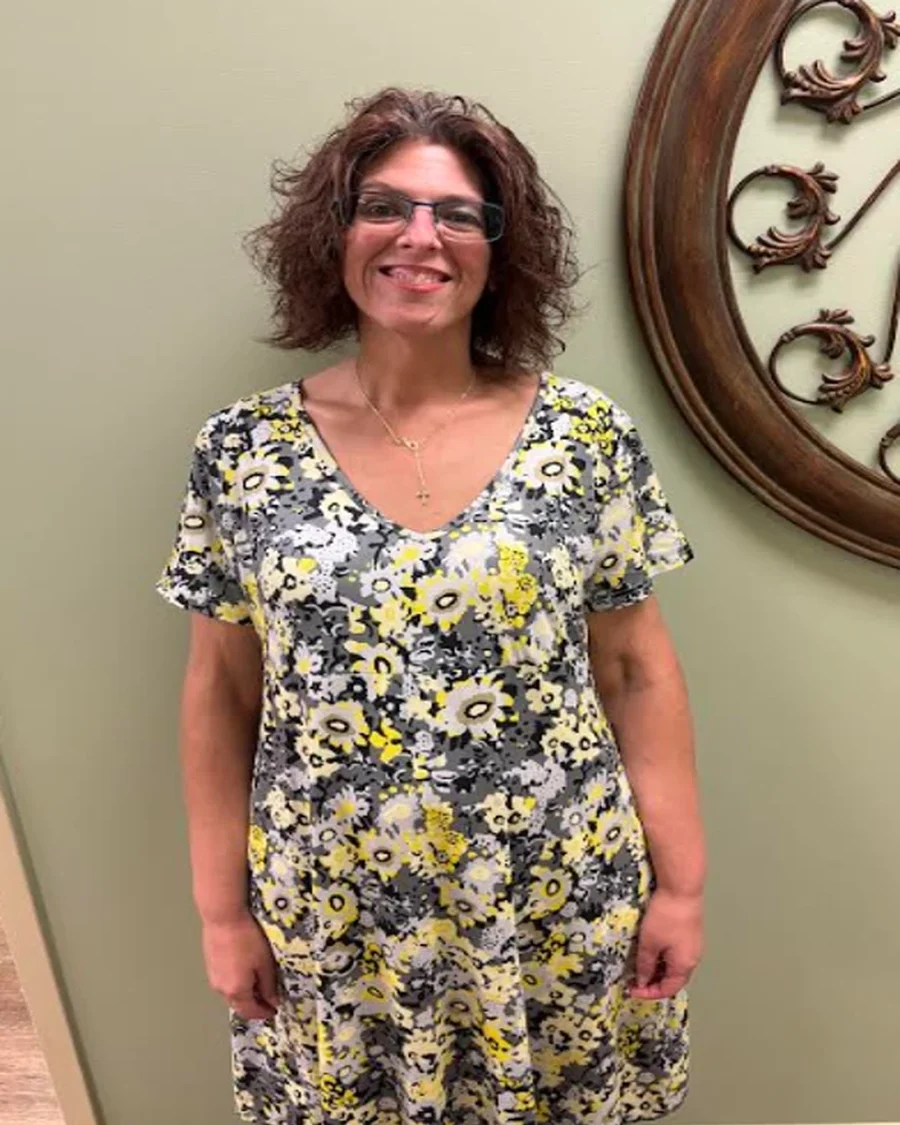 Beverly, Voice Provisioner at iGo Technology, smiling in a floral dress in the iGo office