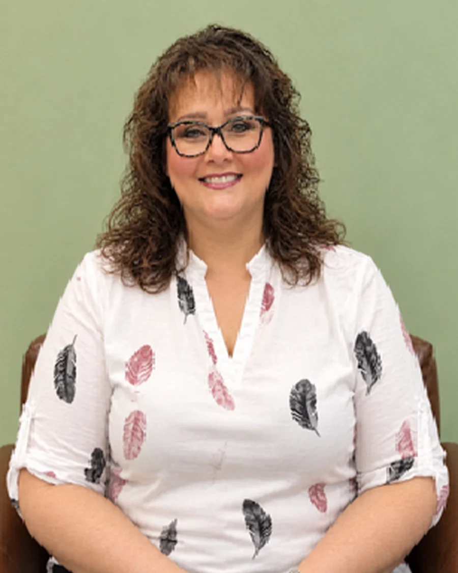 Christine, Marketing Coordinator at iGo Technology, smiling while seated in the iGo office
