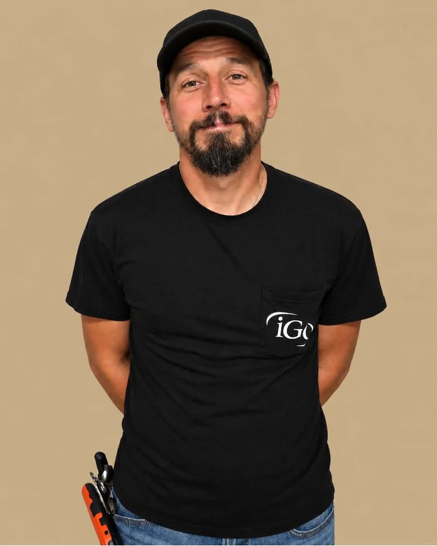 Cody, Lead OSP Engineer at iGo Technology, in a black iGo shirt and cap with tools on his belt